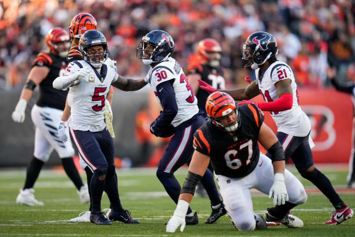 DeAndre Houston-Carson holds the ball and is flanked by two teammates on his side after an interception